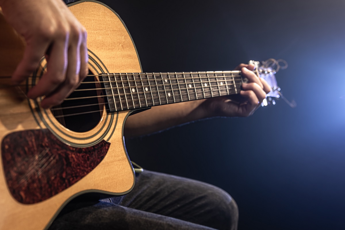 Mão de homem tocando violão